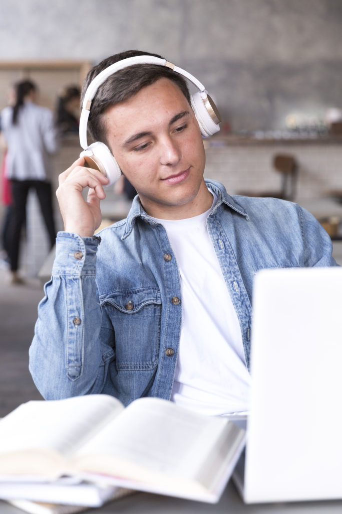 teenage-boy-in-headphones-sitting-at-table-in-classroom faq
